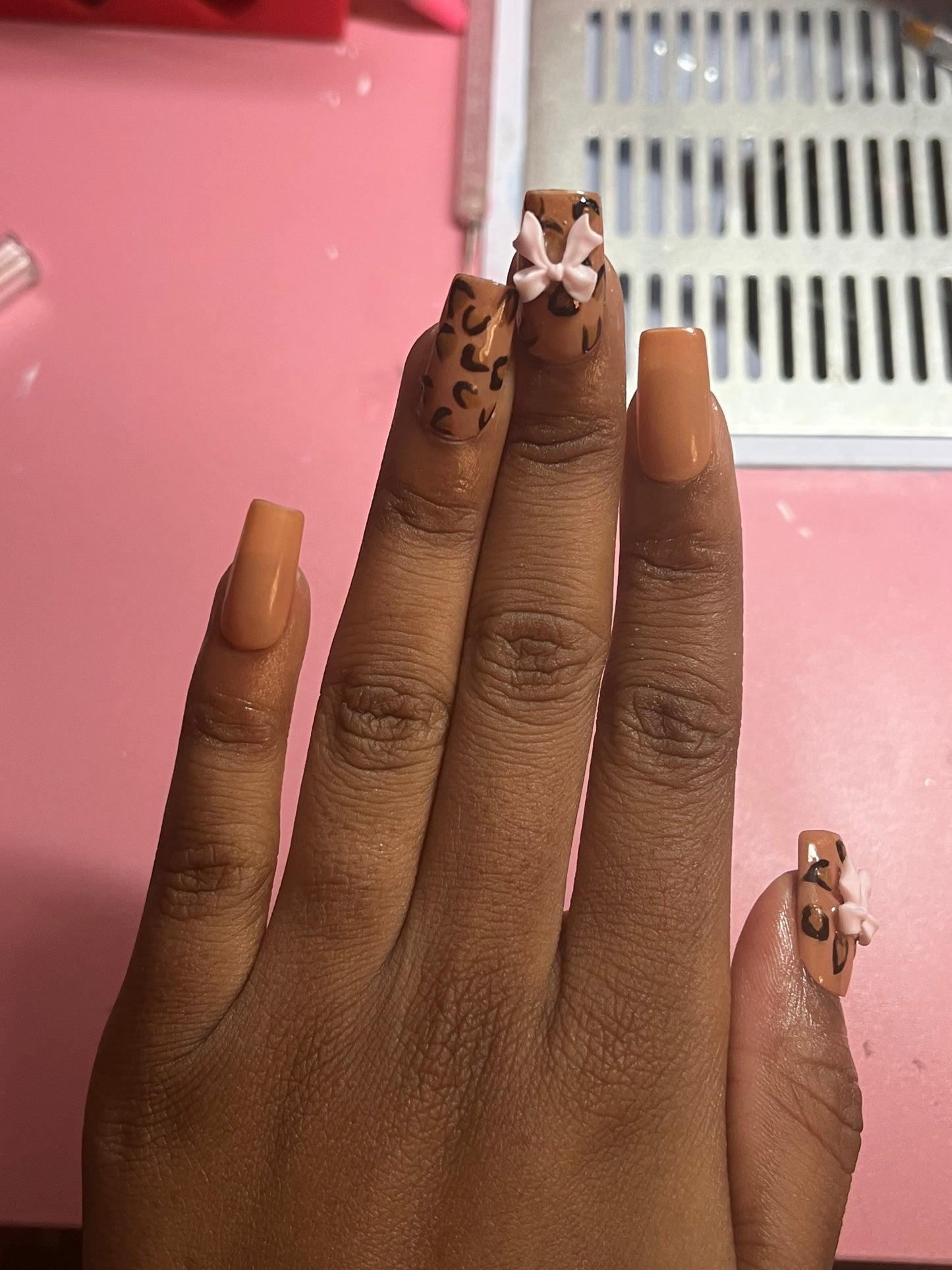 Light brown nails with leopard print and charms